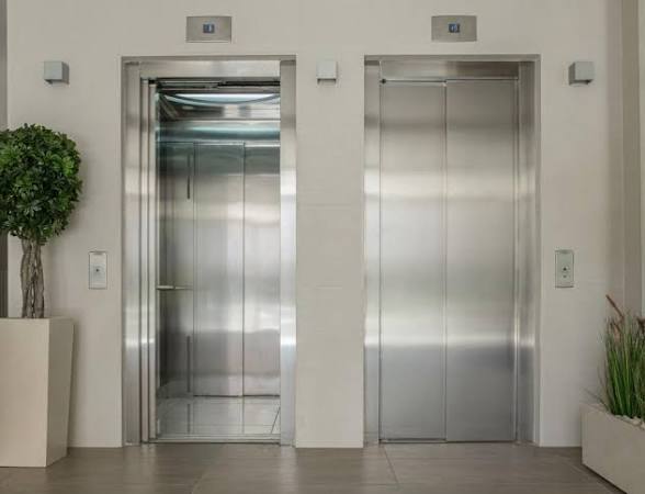 Deux ascenseurs en batterie dans le hall d'un immeuble de bureaux